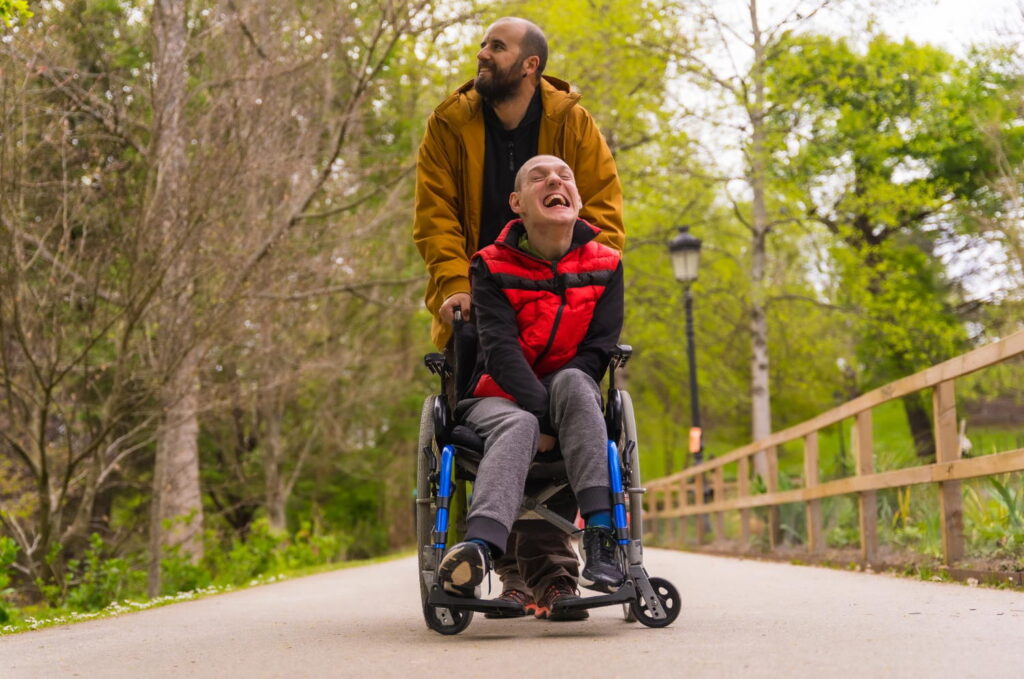 A support worker accompanying a wheelchair user outdoors