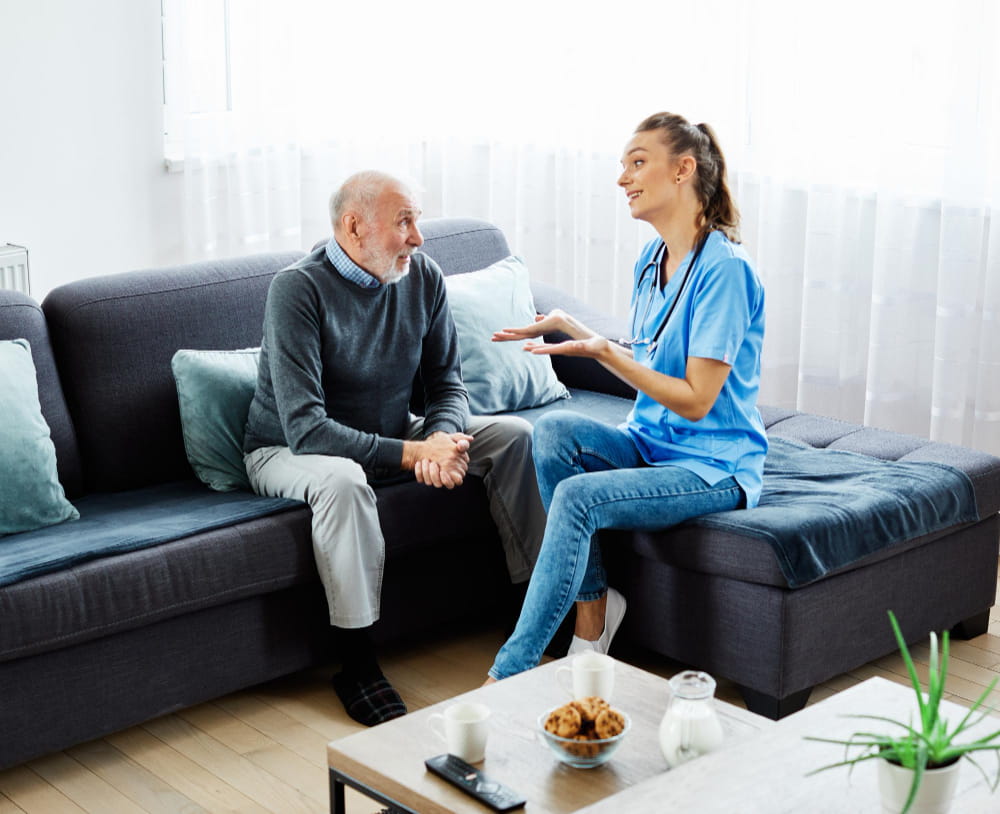 A healthcare professional speaking with an individual at home